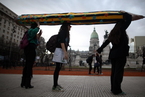阿根廷学生扛巨型铅笔在总统府抗议示威