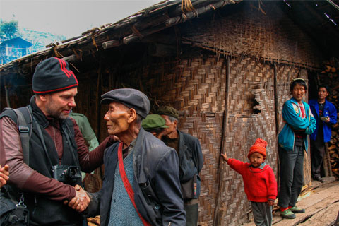 Fritz Hoffmann on assignment for National Geographic magazine being greeted by village party chief on China's border with Myanmar / photo courtesy Fritz Hoffmann