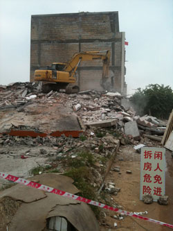 广西北海银滩镇，挖土机正在拆除一栋已将人清走的楼房
