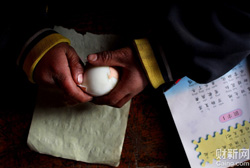宁夏，固原市西吉县西滩乡。西滩中心小学一年级，刘定国，8岁，正在剥鸡蛋皮。