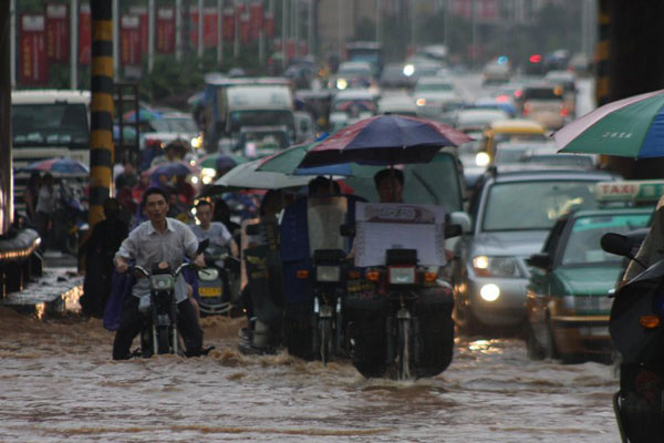 6月13日，湖南省娄底市突下暴雨，许多摩托车冒雨行驶在积水严重的公路上造成堵车。 郭国权/CFP  _湖南娄底突降大暴雨 城市被淹交通受阻
