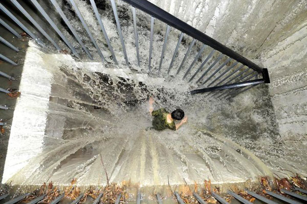 7月3日，成都，一男子在被大水倒灌的小区地下停车场通往地面的人行楼梯上行走。 覃覃/东方IC  _成都遭遇今年最强暴雨 内涝严重交通瘫痪