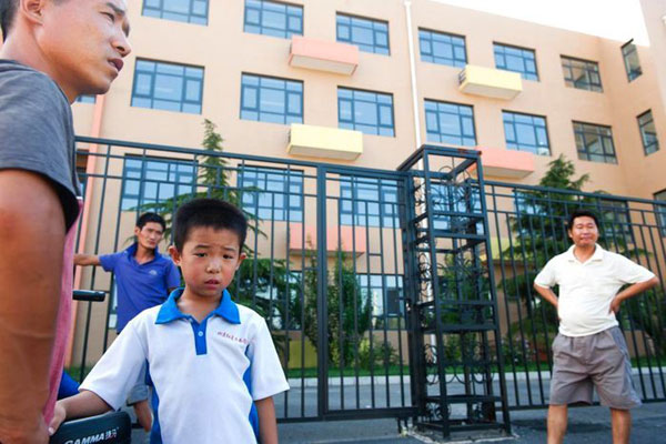 8月18日，北京石油学院附属实验小学门口，几名来看学校的打工子弟学校学生家长被告知此处不是安置学校。 东方IC  _为避免安置分流学生 北京一学校临时更名