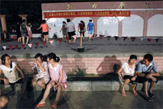 深圳坪山金沙社区入夜时分，居民来到金沙广场聊天，广场台阶上，中老年妇女则跳起健身舞。