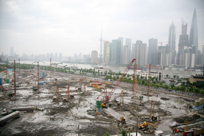 随着2011年的房地产市场调控政策出台，地方的土地财政受创严重。图为2012年6月6日，上海外滩“地王”(8-1)地块工地，工人正在劳作。