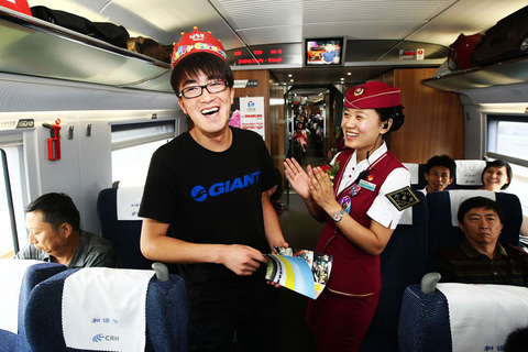 2012年6月30日，为京沪高铁开通一周年， G13次列车举行旅客互动抽奖，图为第一位中奖的幸运旅客，他的礼物是一套京沪高铁集邮册和纪念水杯。