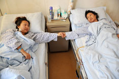 2011年12月26日，在天津第一中心医院，芮明翠（右）转入普通病房术后首次与女儿相见。当日，在天津第一中心医院，因患血吸虫性肝硬化43岁的安徽籍农民芮明翠术后生命体征平稳，从重症监护室转入普通病房，首次与“割肝救母”的女儿杨蓉相见。