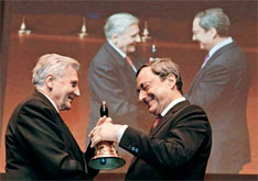 2011年10月19日，德国法兰克福，即将离任的欧洲央行行长特里谢（左）向其继任者、意大利央行行长德拉吉移交一个大铃铛。
