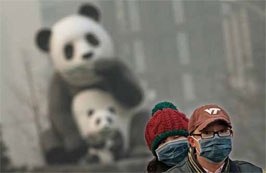 2013年1月23日，北京，市民戴口罩骑摩托车经过一座熊猫雕塑。