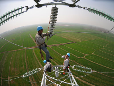 2013年3月7日，安徽省滁州市定远县永康镇大唐村，电力工人在80多米的高空检修供电线路。