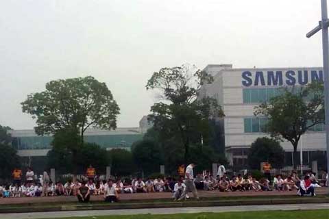 More than 100 people who worked at Bokwang Co.'s factory gather outside one of Samsung's subsidiaries in Suzhou on June 25