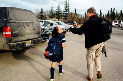 ►Joshua Corbett for The New York Times. 戴维·怀特（David Wight）与女儿伊莎贝拉在阿拉斯加的安克雷奇看完足球赛。“我很幸运，”他说。