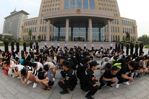 Police make arrest of over 100 suspects linked to phone scams in Xuchang in Henan Province on June 28. Photo: Visual China
