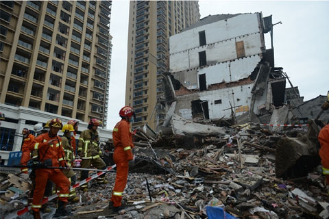 Rescue workers comb through the rubble at the site where four buildings collapsed in Wenzhou's Lucheng District on Monday killing 22 migrant workers. Photo: Visual China