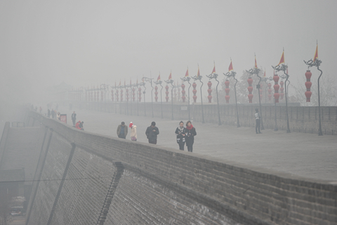 Tourists brave heavy smog to visit a stretch of ancient city wall in Xi'an, Shaanxi province on December 8, 2015. Photo: Visual China