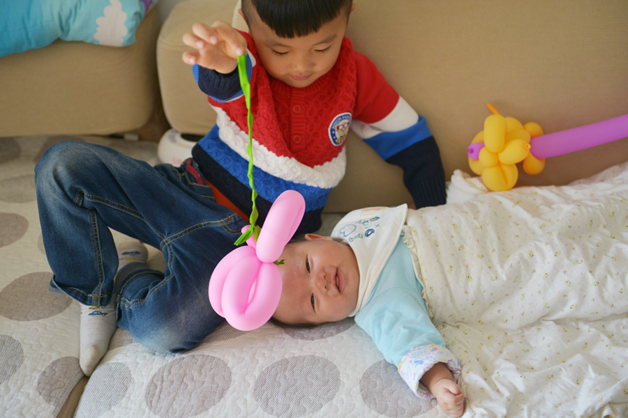 A boy plays with his little brother, who was born after China abolished its one-child policy in 2015. Photo: Visual China