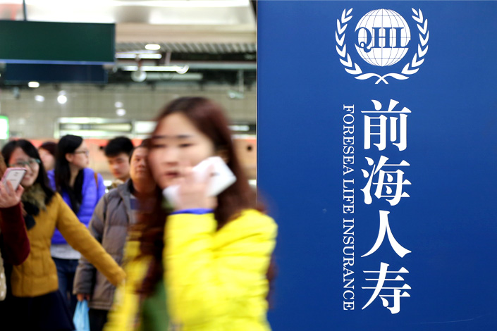 Passengers walk by an advertisement for Foresea Life Insurance in a Shanghai subway station on Dec. 7, 2014. Photo: IC