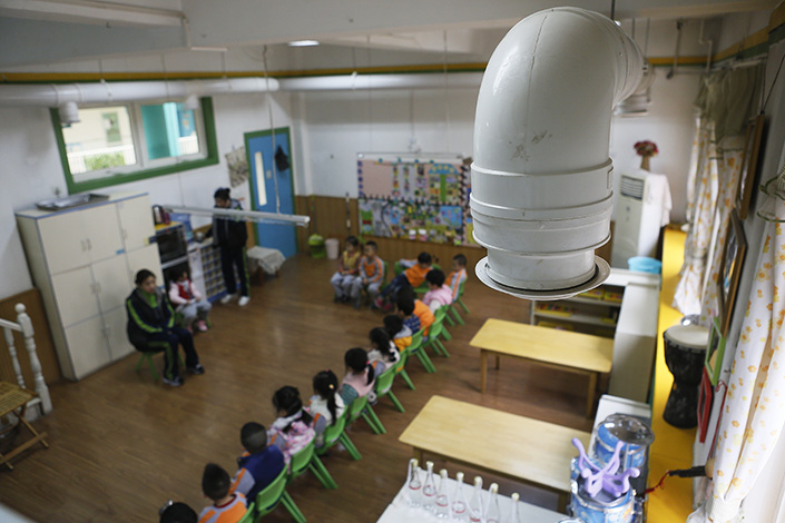 A smog-filtering ventilation system is visible in a classroom in Xi'an, Shaanxi province, on Jan. 9. Experts called for standardized clean-air ventilation systems for all schools in smog-filled areas. Photo:Visual China
