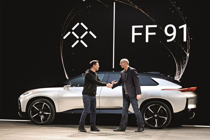 Jia Yueting (left), founder and CEO of LeEco, shakes hands with Nick Sampson, Faraday Future's senior vice president of product R&D and engineering, in front of a Faraday Future FF91 electric car at its unveiling at the CES 2017 electronics trade show in Las Vegas, Nevada, on Jan. 3. Photo: CFP