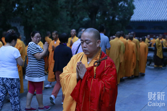 Hundreds of monks at the Shaolin Monastery, under the guidance of abbot Shi Yongxin, pray on Aug. 14, 2015, for those killed and wounded in the Port of Tianjin explosions. Photo: Chen Liang