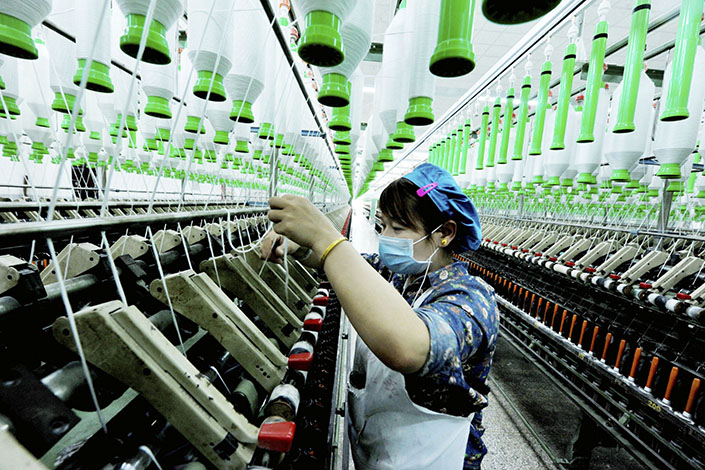 China's gross domestic product growth accelerated year-on-year for the second straight quarter in the January-through-March period. Above, a Chinese worker handles production of yarn at a textile factory in Yushan county, Jiangxi province, on March 28. Photo: IC