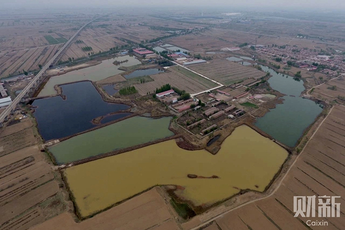 Six ponds next to a high-speed rail line running through the Tongjiazhuang village in Jinghai district, Tianjin. The six ponds are connected by dikes and cover an area of 150,000 square meters. Photo: Chen Weixi/Caixin