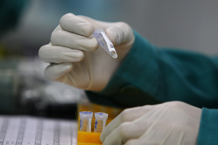 A technician checks the information on a DNA sample in a laboratory of Huada in Yantian, Shenzhen, on July 1, 2015. Photo: Visual China