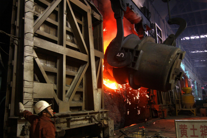 Hunan Valin Xiangtan Iron and Steel Co. Ltd. says its production assets are doing well enough that it can abandon its planned transition into financial services. Above, a steelworker watches a steel making converter in Loudi, Hunan province, in December 2007. Photo: Visual China