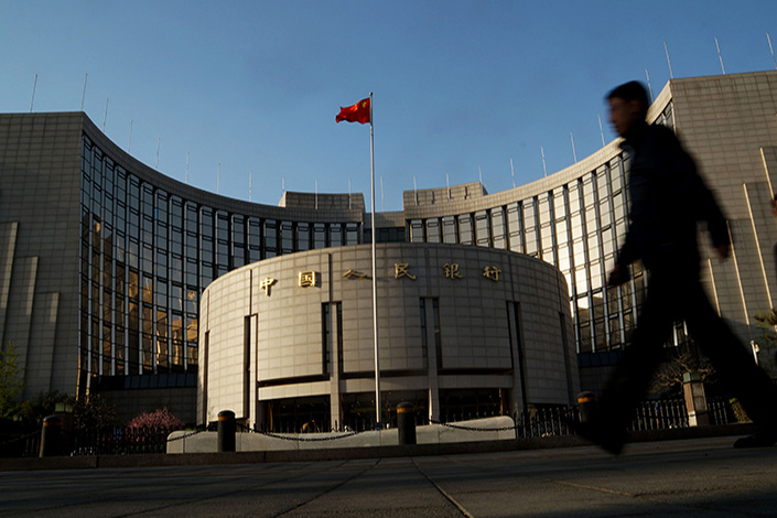 China’s central bank said late Monday that foreign credit ratings agencies can assess the credit risks of onshore interbank bonds. Above, a man strides past the People’s Bank of China in Beijing in April 2014. Photo: IC