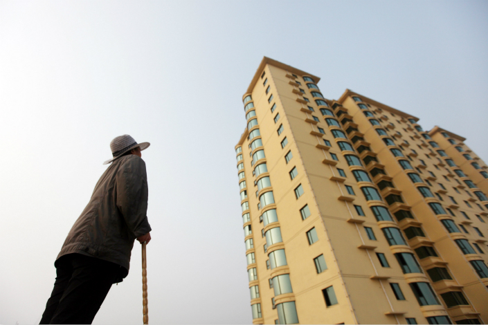 Chinese real estate developers issued 32 offshore bonds worth a total of 121.3 billion yuan ($18.04 billion) from May through July 25, and the total for the year through July 25 surpassed that for all of 2016. Above, a man examines a high-rise building in Anyang, Henan province, in September 2013. Photo: Visual China