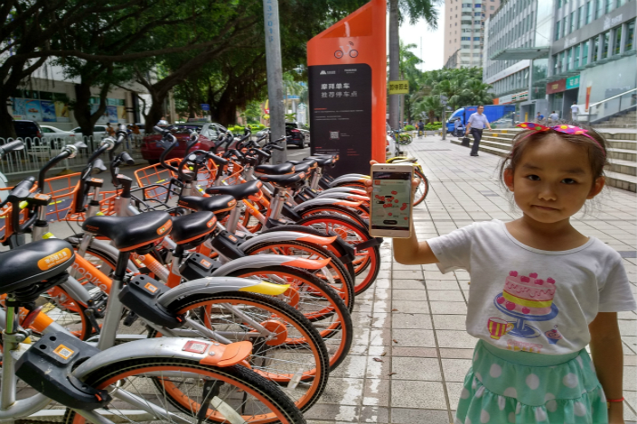 Mobike users in major cities across China say they were unable to unlock the company’s trademark orange and silver two-wheelers at about 9 a.m. on Thursday. Above, a girl shows the Mobike app on a smartphone this month in Shenzhen. Photo: Visual China