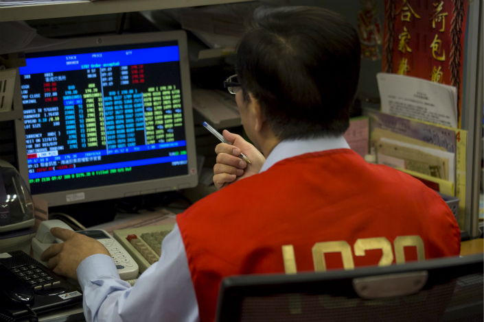 The Hong Kong Stock Exchange's proposal to create a third board for companies too small for the bourse's two existing boards still has points of contention. Above, a Hong Kong floor trader checks share prices during morning trading at the Hong Kong exchange in July 2015. Photo: Visual China