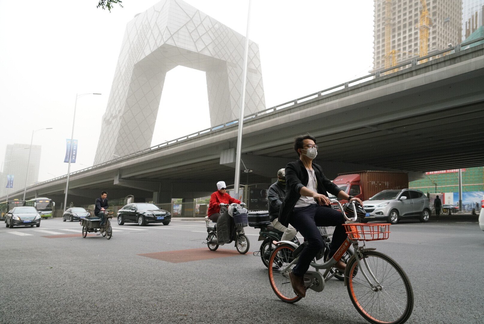 The Chinese government has for the first time set emission-cut targets for cities in the Beijing-Tianjin-Hebei region and nearby areas for the winter season. Above, motorists and bicyclists battle smog during a polluted day in Beijing. Photo: IC