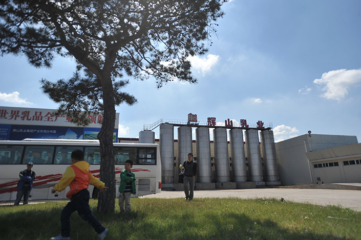 China Huishan Dairy is facing a demand from HSBC Holdings PLC that Huishan immediately repay a $200 million loan that it has defaulted on. Above, children play in front of the Huishan plant in Shenyang, Liaoning province, in May 2014. Photo: IC