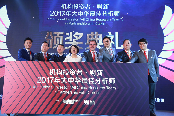 Caixin Media Editor-in-Chief Hu Shuli (fourth from left) and other representatives of Caixin and Institutional Investor host their companies' inaugural awards ceremony Wednesday in Beijing as they recognized the best analysts of China's business. Photo: Caixin