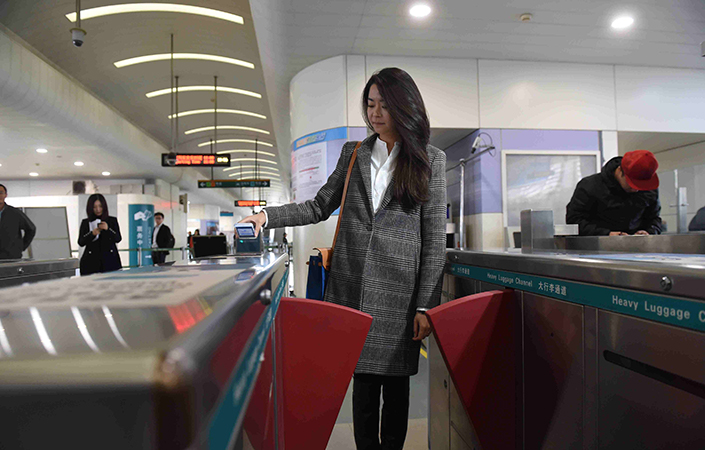 Tencent and Alibaba have been racing to get their rival mobile payment platforms installed in public transportation systems across China, from subways to public buses. Above, a passenger on the Shanghai maglev line uses her mobile phone to pay for her ride on Oct. 30. Photo: IC