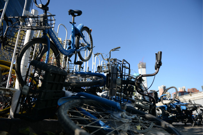 Bluegogo bicycles sit in a heap in Beijing on Nov. 30. The company, one of dozens of bike-sharing startups that have mushroomed in Chinese cities in recent years, was hit by a capital crunch late last year, with reports emerging that it owed its suppliers more than 200 million yuan ($31 million). Photo: IC