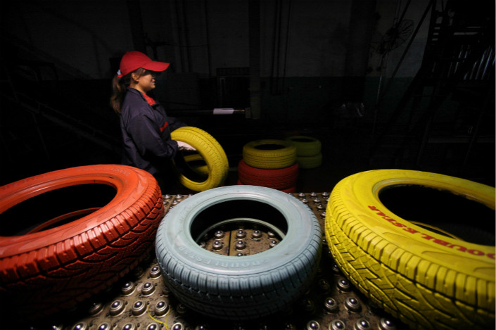 A worker carries one of Doublestar Group’s colored tires at a facility in Shiyan, Hubei province in November 2011. Photo: VCG