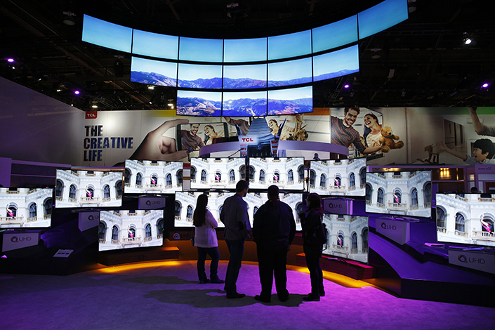 Visitors to the 2016 CES International electronics trade show in Las Vegas check out ultra-high definition TVs at the TCL booth. Photo: IC