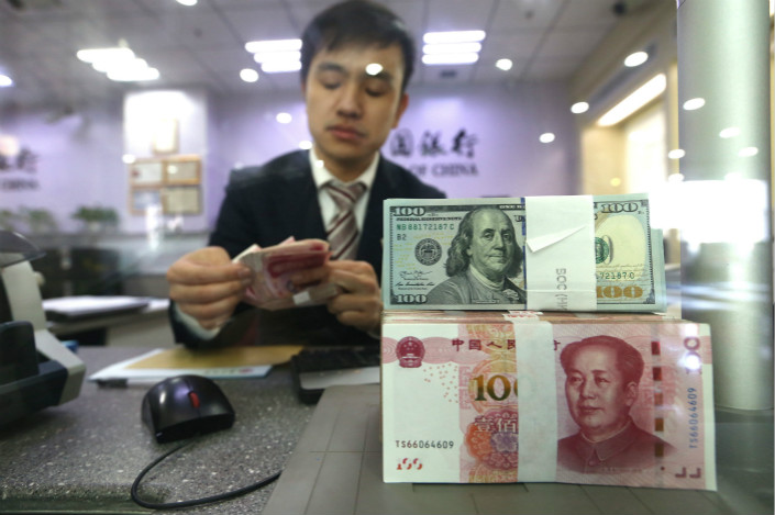 A bank employee counts money on Saturday in North China’s Shanxi province. Photo: VCG
