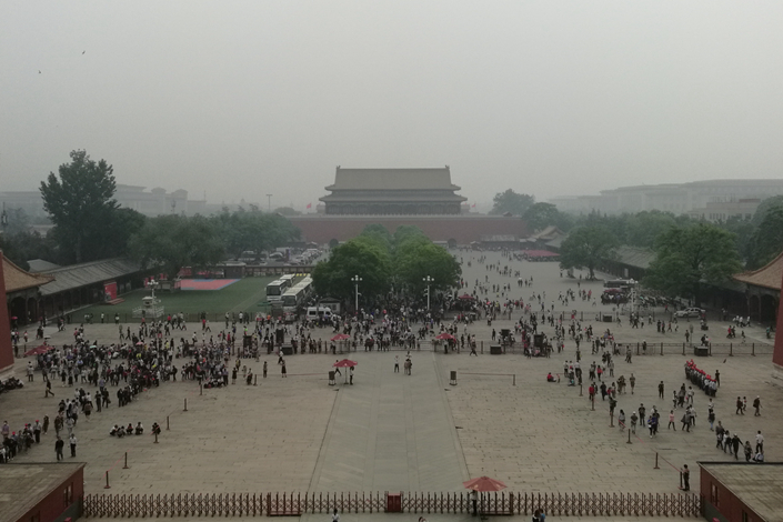 Tourists swarm into Beijing’s Forbidden City during unusually heavy smog on May 12. Photo: Wu Gang/Caixin