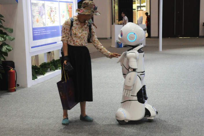 An attendee at the Fifth China International Service Trade Fair interacts with a robot possessing artificial intelligence on May 29. Photo: VCG