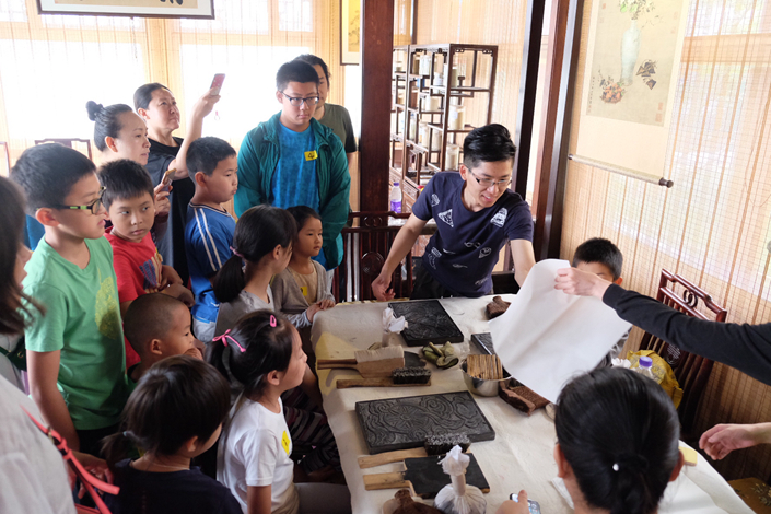 Students attend a lesson about traditional Chinese printing methods hosted by Beijing's Summer Palace on June 9. Photo: Wu Gang/Caixin