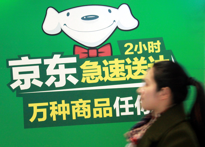 A woman walks past an advertisement for JD.com's Daojia grocery delivery service in Nanjing on Dec. 9, 2016. Photo: VCG.