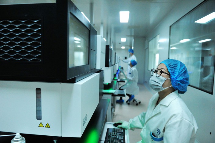 Researchers operate gene-sequencing equipment in Qingdao, East China's Shandong province on May 29. Photo: IC