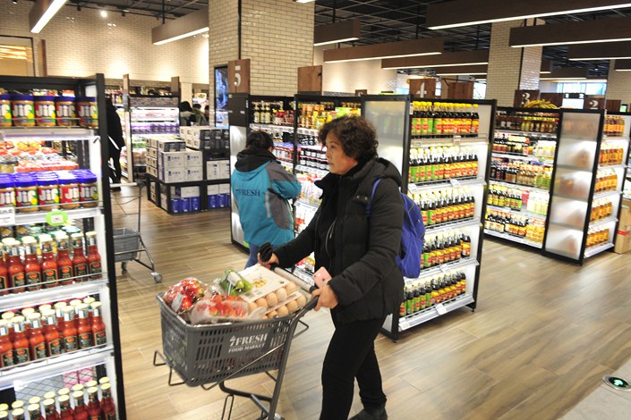 A customer buys produce at the first brick-and-mortar store of 7Fresh, the fresh food supermarket chain launched by online retailer JD.com in Beijing on Jan. 5. Photo: VCG