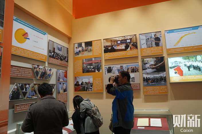 Museum visitors examine a corner of the exhibition devoted to the successes of the anti-corruption campaign. Photo: Zhang Zizhu/Caixin
