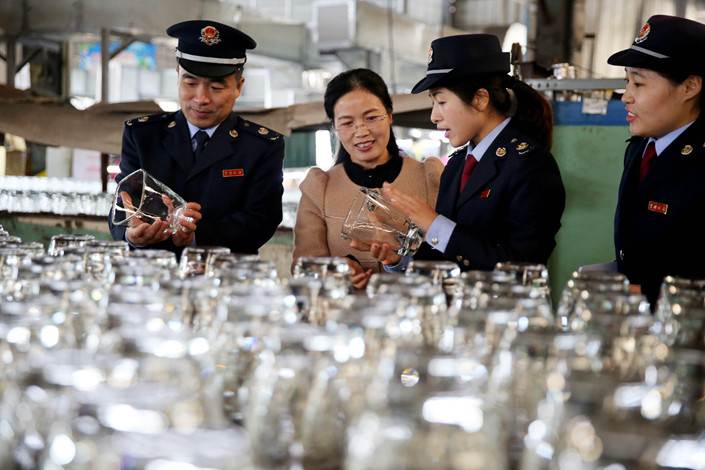 Tax collectors in Huaibei, Anhui province explain polcies to an exporter on Nov. 15. Photo: IC