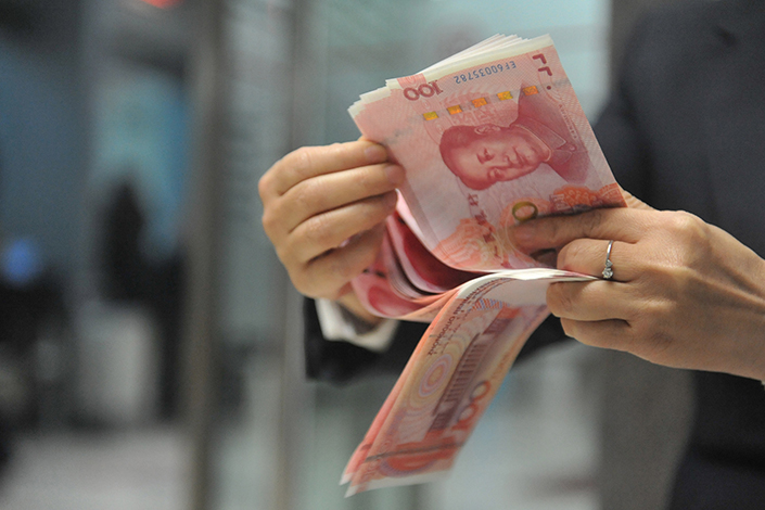 A clerk counts yuan notes at a bank in Hangzhou, Zhejiang province, on Nov. 12, 2015. Photo: VCG