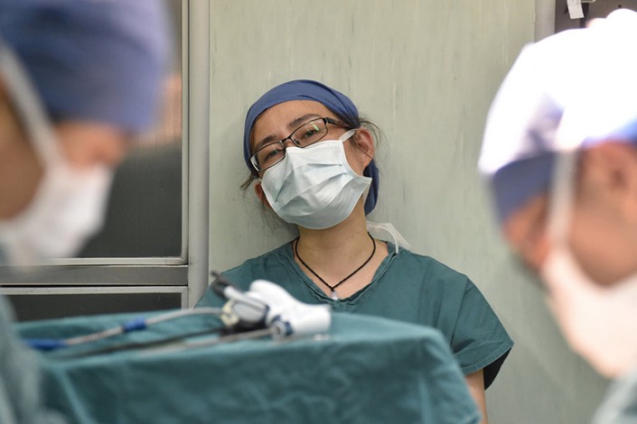 A doctor takes a break after a surgical procedure at a hospital in Hangzhou, Zhejiang province on Oct. 8, 2015. Photo: VCG
